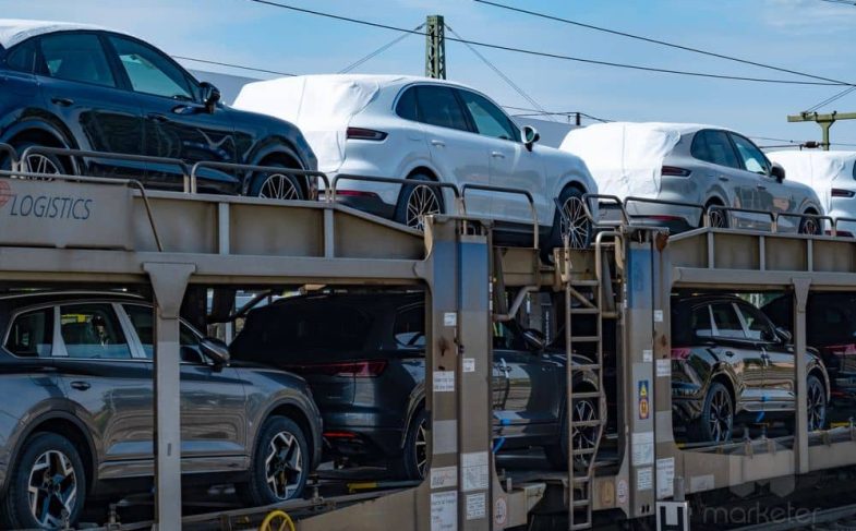 Freight train transporting convoy brand-new Porsche macan